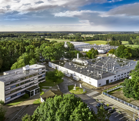 Ein Team von älteren Frauen und Männern steht in einer Industrieküche und ist fröhlich